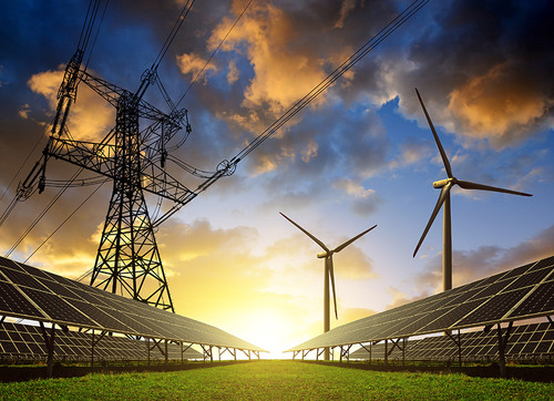 Mehrere Photovoltaikanlagen, zwei Windräder und ein Starkstrommasten im Lichte des Sonnenuntergangs