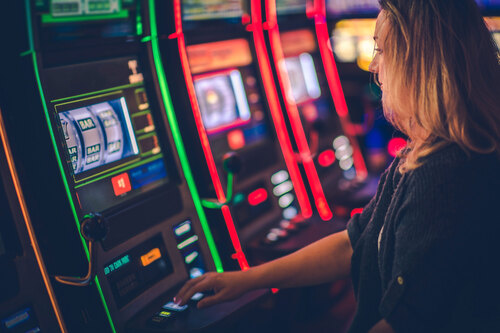 Frau spielt an einem Glücksspielautomaten