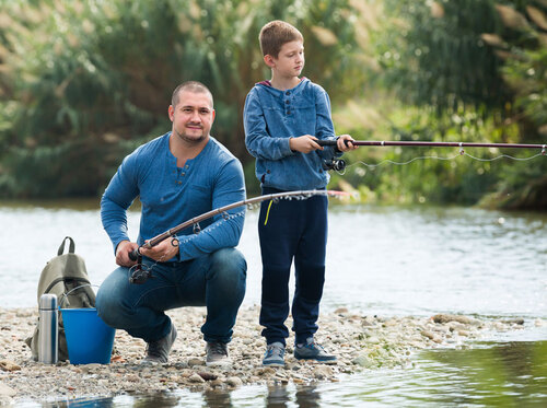 Mann und Junge beim Fischen an einem Fluss