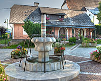 Brunnen am Ortsplatz von Großraming, im Hintergrund farbiges Haus (Filmkulisse zum Dreh 'Die Landärztin'