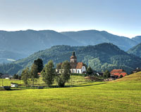 Blick auf die Kirche Großraming inmitten grüner Wiesen