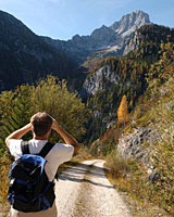 Wanderer blickt mit Fernrohr auf die Berge