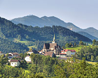 Fernblick auf die Kirche in Maria Neustift, umgeben von Wiesen und Wäldern